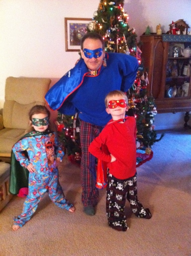 Picture of Chris and his kids dressed like generic super heroes (masks and capes)