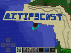 A.T.TIPSCAST spelled out in blue blocks on sandy peninsula in Minecraft
